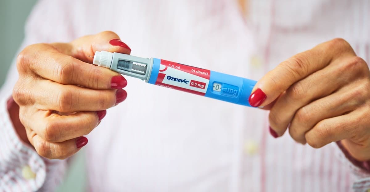 Photo illustration of a woman holding an Ozempic pen.